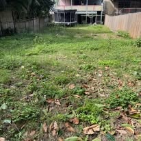 Messy overgrown yard before lawn care — Brisbane